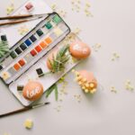 Easter eggs with 'love' text and paint palette in a spring-themed creative flat lay scene.